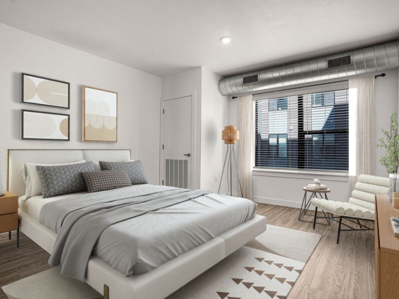 Bright bedroom at Solis at Jackson Station featuring modern decor, large windows, and wood-style flooring.