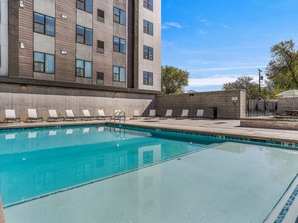 Sparkling outdoor pool at Solis at Jackson Station surrounded by lounge chairs and modern architecture.