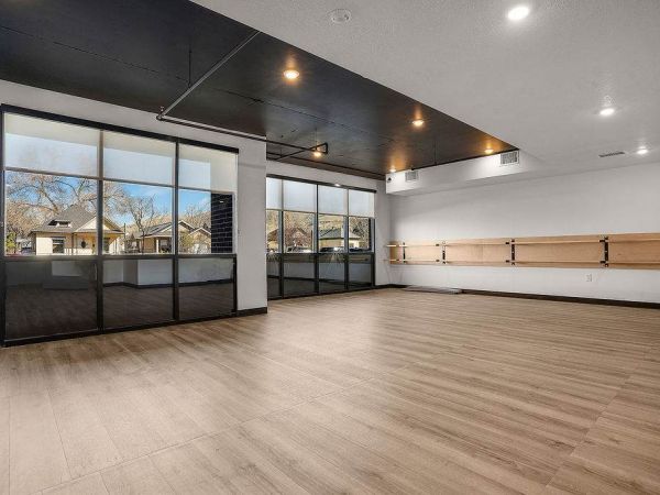 Spacious yoga and fitness studio at Solis at Jackson Station featuring wood-style flooring, mirrored walls, and large windows with natural light.