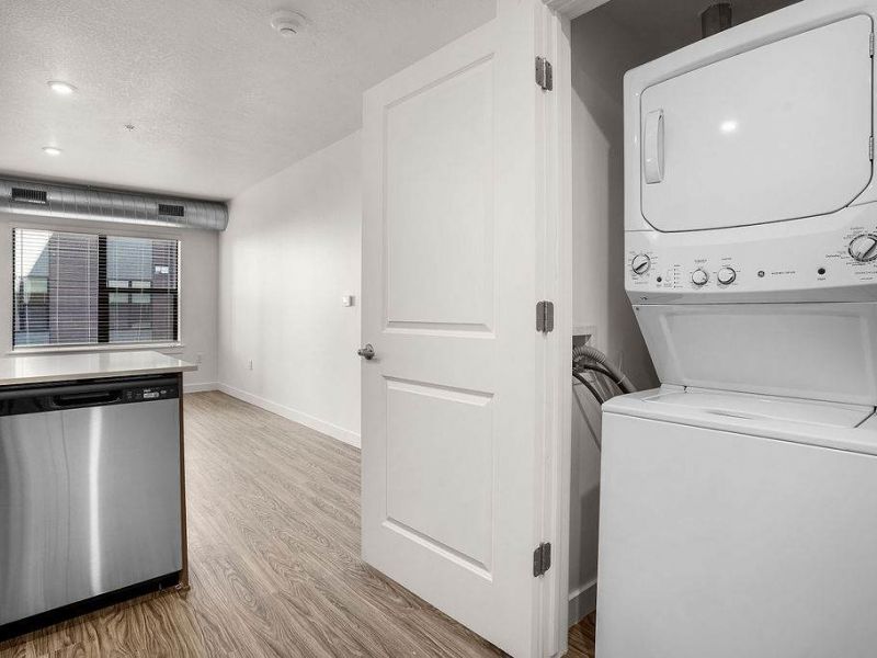 Open apartment interior at Solis at Jackson Station featuring in-home washer and dryer, modern flooring, and bright natural light.